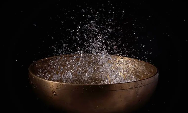 A singing bowl lit against a dark background